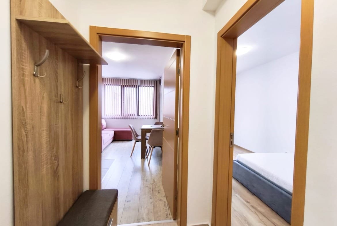 Коридор квартиры в Болгарии с дверями в комнаты, светлый интерьер, стильная мебель и просторное пространство.