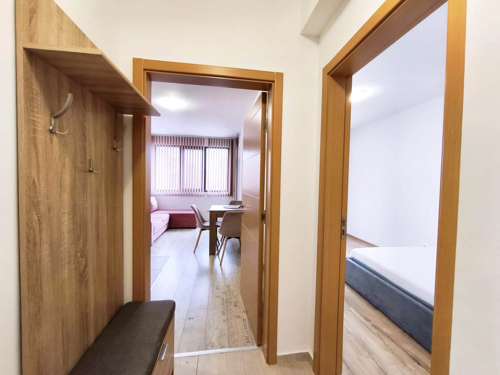 Современный интерьер прихожей с выходом в комнату и спальню Коридор квартиры в Болгарии с дверями в комнаты, светлый интерьер, стильная мебель и просторное пространство.