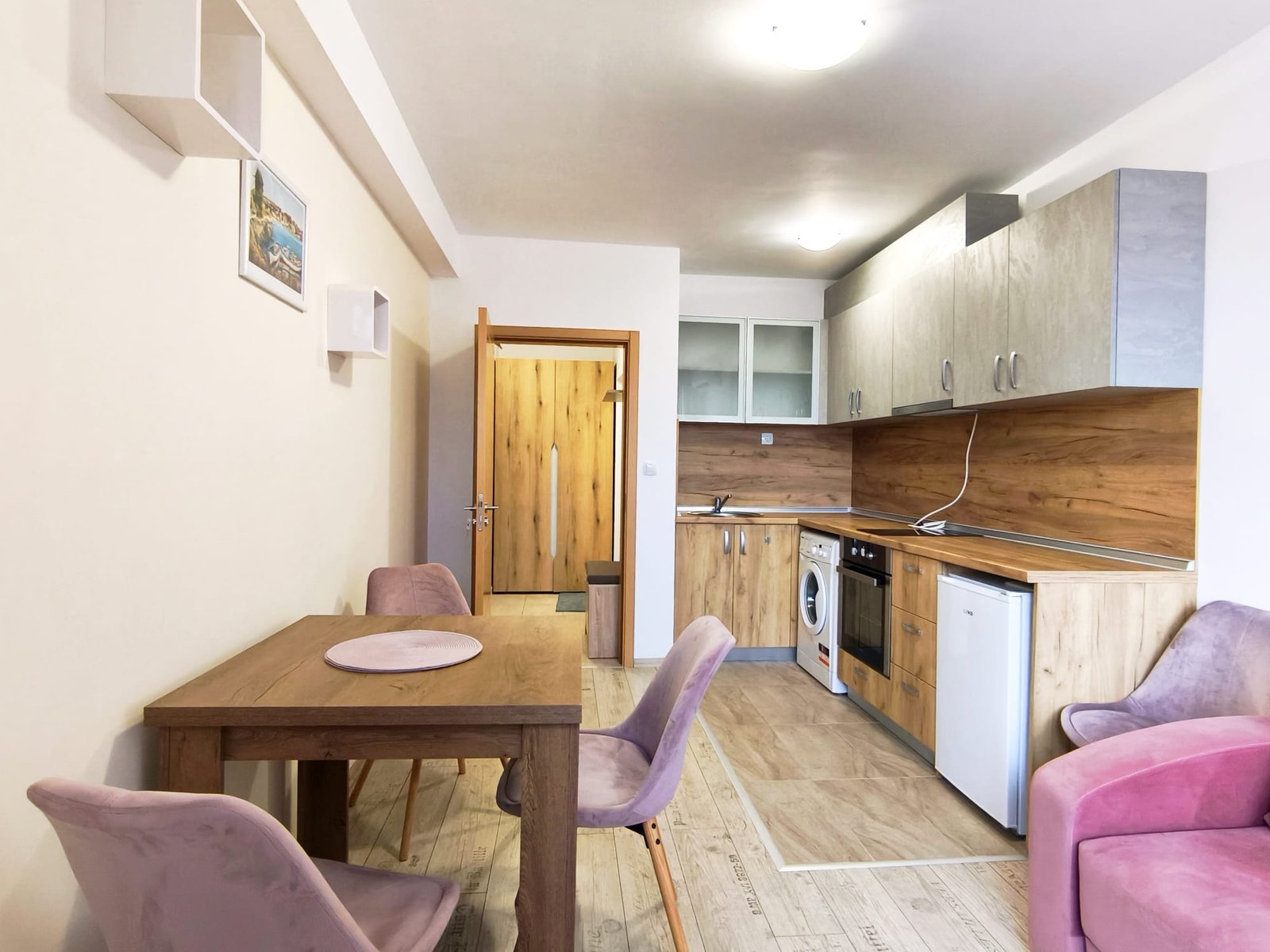 Современная кухня в светлых тонах с обеденным столом Современная квартира в Болгарии с кухней и столовой, светлые тона, деревянные элементы, уютная обстановка, подходит для жизни или аренды.